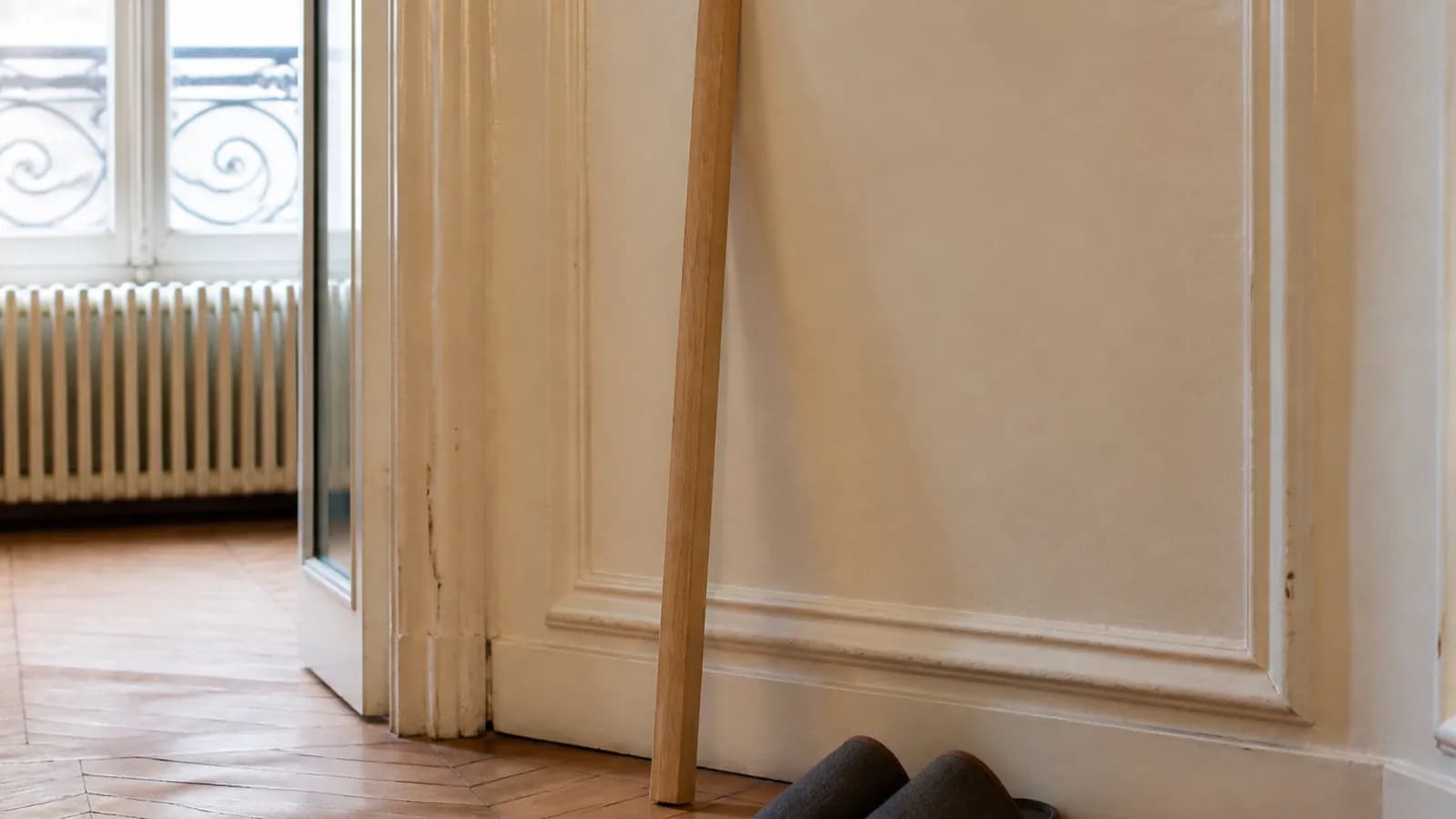 Personne debout contre un mur, toise en bois à côté, illustration de la taille utilisée pour l’IMC.